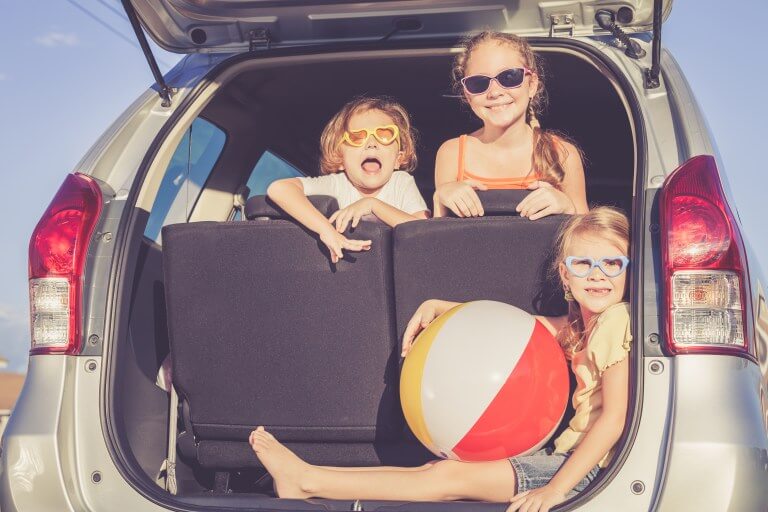 Smiling Kids at the back of an SUV