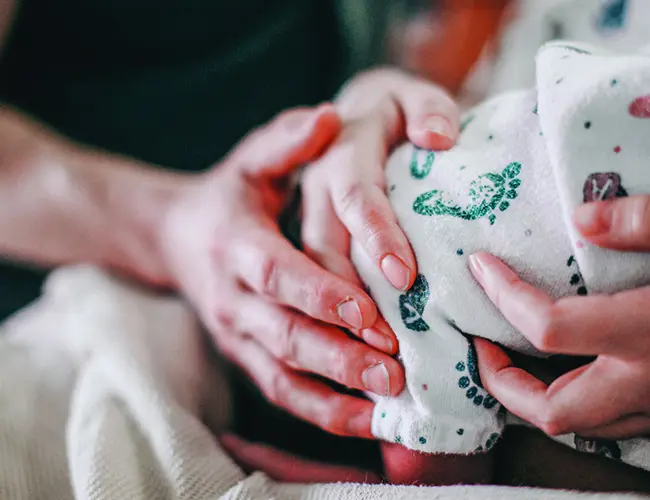 Mother and father holding their newborn baby