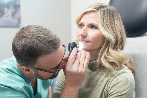 Dermatologist performing acne check and evaluation